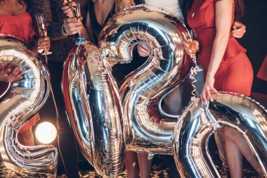 2020 yılının yeni sayıları şeklinde balonlar tutan insanlar..