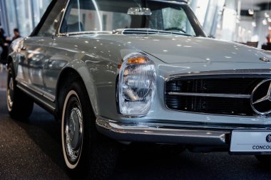 Stuttgart, Almanya - 16 Ekim 2018: Mercedes Müzesi. Önde ve sağda. Arka plandaki insanlar bulanık. İki koltuklu beyaz sedan, uzay gösteri odasına park edilmiş..