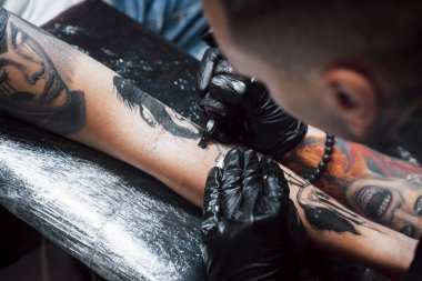 Dövme makinesini kapat. Siyah steril eldivenler ustası. Kuaförde resim yapıyor..