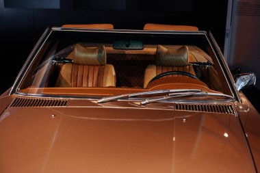 Ön, bej renkli eski arabanın yakın görüntüsü deri iç ve parlak kaput: direksiyon simidi, arka ayna ve ön cam..