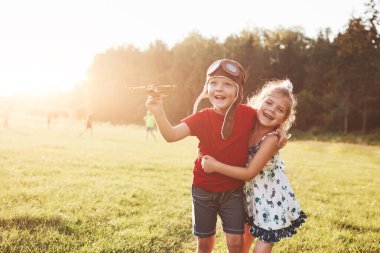 Erkek ve kız kardeş birlikte oynuyorlar. Dışarıda tahta bir uçakla oynayan iki çocuk..