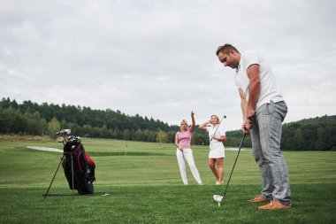 Golf sahasındaki bir grup şık arkadaş yeni bir oyun öğreniyor..