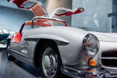 Kapılar bir kanat gibi ardına kadar açık. Bir otomobil fuarında kırmızı klasik araba..