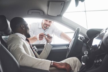 Genç siyahi iş adamı test sürüşü yapıyor. Zengin Afro-Amerikan erkeği.