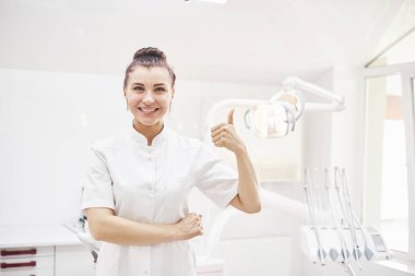 Tıbbi geçmişinde aletleri olan mutlu genç bir dişçi. Stomatoloji ve sağlık konsepti.