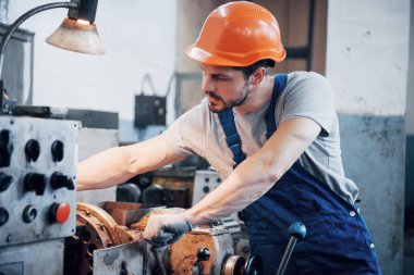 Başlık takmış deneyimli bir operatör. Metal endüstrisi konsepti profesyonel mühendis metal işçisi imalat atölyesinde Cnc değirmen makine merkezi işletiyor.