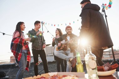 Muhteşem güneş ışığı. Yemekle birlikte bir masa. Hafta sonu çatıda gitar, alkol ve pizzayla..