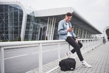 Ofisin yanında genç ve yakışıklı bir adam konuşuyor.