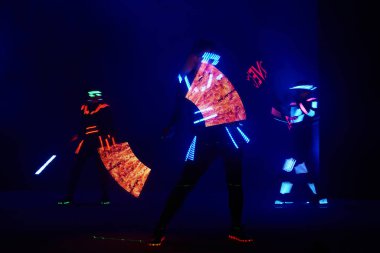 Laser show performance, dancers in led suits with LED lamp, very beautiful night club performance, party.