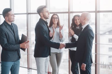 Ofisteki bir toplantıda el sıkışan iki kendine güvenen iş adamı, başarı, anlaşma, selamlama ve ortaklık kavramı.