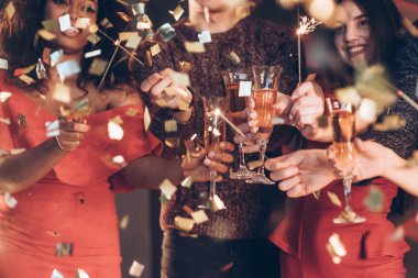 Keyfin yerinde ve iyi vakit geçiriyorsun. Çok ırklı arkadaşlar yeni yılı kutluyor. Bengal ışıkları ve bardaklarla içki içiyorlar..