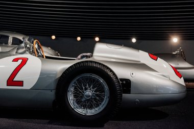 Yan, gri retro spor coupe Cabriolet 'in yakın görüntüsü, sol kapısında 2 numaralı kırmızı boya, tahta direksiyon, ayna, arka planda çok sesli alaşım diskler ve klasik araba..