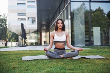 Güneşli bir yaz sabahı. Genç atletik kadın şehir parkı caddesinde modern şehir binaları arasında amuda kalkıyor. Açık havada egzersiz yapmak sağlıklı bir yaşam tarzı..