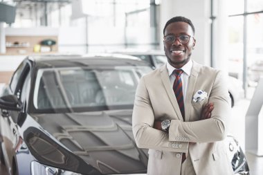 The young attractive black businessman buys a new car, dreams come true. clipart