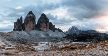Sabahları üç görkemli Tre Cime dağının manzarası ve üzerinde açık gökyüzü. Panoramik fotoğraf.