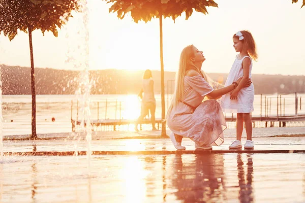 Madre Con Bebé Cerca Fuente Atardecer — Foto de Stock