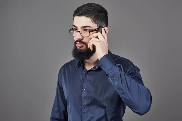 Homem Feliz Óculos Fala Por Telefone Fundo Cinza — Fotografia de Stock