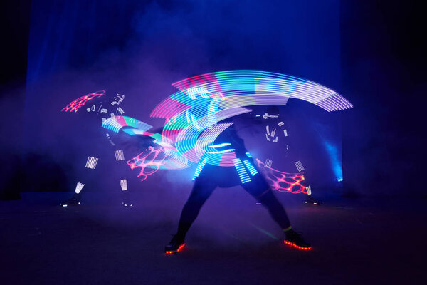 Laser show performance, dancers in led suits with LED lamp, very beautiful night club performance, party.
