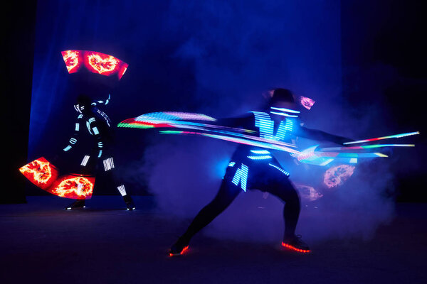 Laser show performance, dancers in led suits with LED lamp, very beautiful night club performance, party.