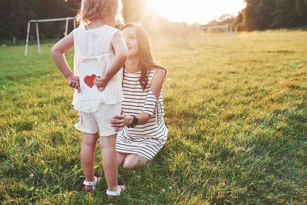 Girl Hides Book Red Heart Back Smiling Sitting Mother — Stock Photo, Image