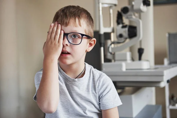 画像に集中します 小さな男の子は彼の目をカバーし 診療所で視力を確認している — ストック写真