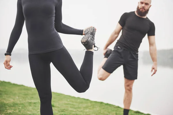 Fitnesspaar Dat Zich Buiten Het Park Bij Het Water Uitstrekt — Stockfoto