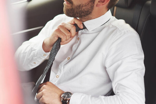 A beautiful young man is preparing to meet in full suit