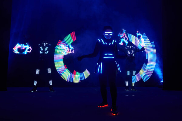 Laser show performance, dancers in led suits with LED lamp, very beautiful night club performance, party.