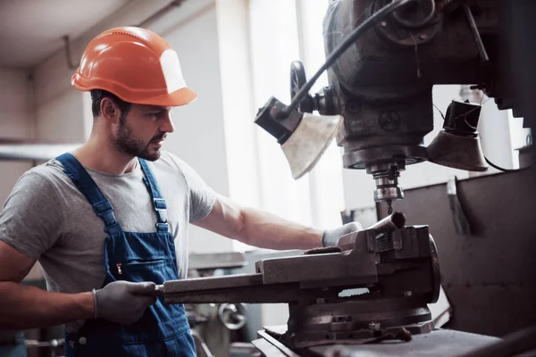 Başlık takmış deneyimli bir operatör. Metal endüstrisi konsepti profesyonel mühendis metal işçisi imalat atölyesinde Cnc değirmen makine merkezi işletiyor.