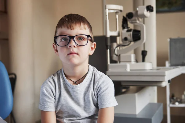 Retrato Criança Sentada Com Óculos Clínica Médica Com Equipamento Oftálmico — Fotografia de Stock