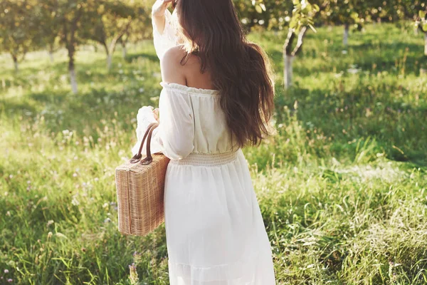 Młoda Dziewczyna Białej Długiej Sukience Spaceruje Ogrodzie Piękny Zachód Słońca — Zdjęcie stockowe