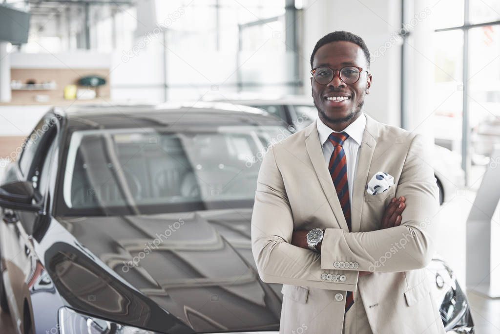 The young attractive black businessman buys a new car, dreams come true.