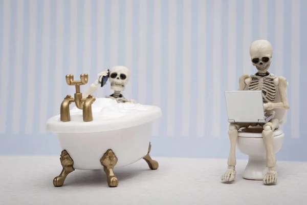 Zwei Skelette plaudern und arbeiten im Badezimmer lizenzfreie Stockfotos