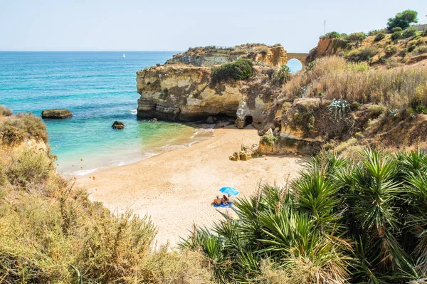 Student plaży lub Praia dos Estudantes w Lagos, Portugalia. Kilka lokalizacji na plaży pod niebieski parasol. — Zdjęcie stockowe