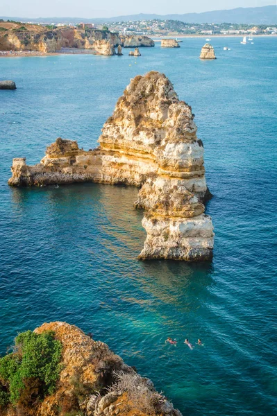 Ludzie, pływanie w morzu na linii brzegowej Lagos wybrzeży, Algarve, Portugalia. — Zdjęcie stockowe