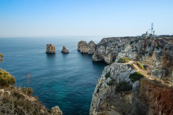 Widok krajobrazu z linii brzegowej Lagos wybrzeża w tle Farol da Ponta da Piedade, Algarve, Portugalia — Zdjęcie stockowe