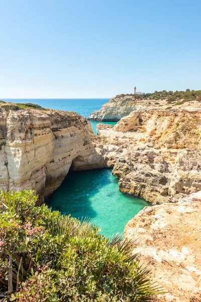 Blick auf Grottenhöhle, türkisfarbene Lagune, Kalksteinfelsen und Leuchtturm an der Küste von Algarve, Portugal, Europa — Stockfoto