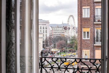 Budapeşte, Macaristan - 14 Aralık 2019: Madach Meydanı penceresi gün batımından sonra Noel alışveriş fuarı pazarıyla Deak 'a doğru açılıyor.