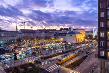 Budapeşte, Macaristan - 14 Aralık 2019: Madach Meydanı penceresi gün batımından sonra Noel alışveriş fuarı pazarıyla Deak 'a doğru açılıyor.