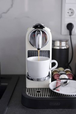 Budapest, Hungary - April 18, 2019: Coffee making process with household DeLonghi nespresso machine.