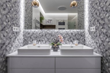 Budapest, Hungary - April 18, 2019: Double sink in a luxurious white marble bathroom in an Airbnb accommodation, straight view.
