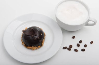 Beyaz fincan kapuçino beyaz zemin üzerine çikolatalı kek ile