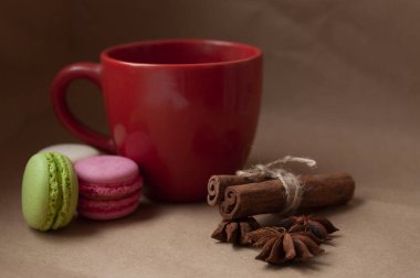 Kırmızı bardakta badem kurabiyesi ve el işi kağıdında baharatlar.