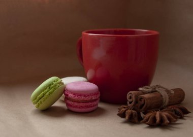 Kırmızı bardakta badem kurabiyesi ve el işi kağıdında baharatlar.