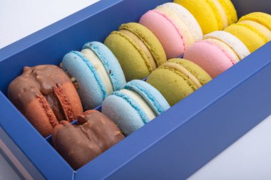 Mavi kutudaki özel badem kurabiyeleri beyazın üzerinde izole edilmiş.