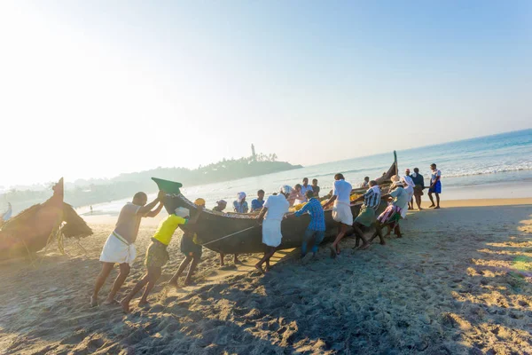 Kovalam villageois poussant bateau de pêche plage — Photo