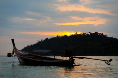Longtail tekne Ko Lipe kıyı şeridi bulutlu gökyüzü günbatımı