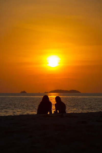 Dos personas silueta viendo puesta de sol playa océano — Foto de Stock
