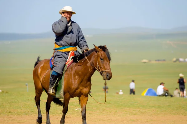 Hombre mongol a caballo usando teléfono móvil — Foto de Stock