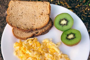 Beyaz Tabakta Tam Kahvaltı Kivi Yumurtalı Ekmek